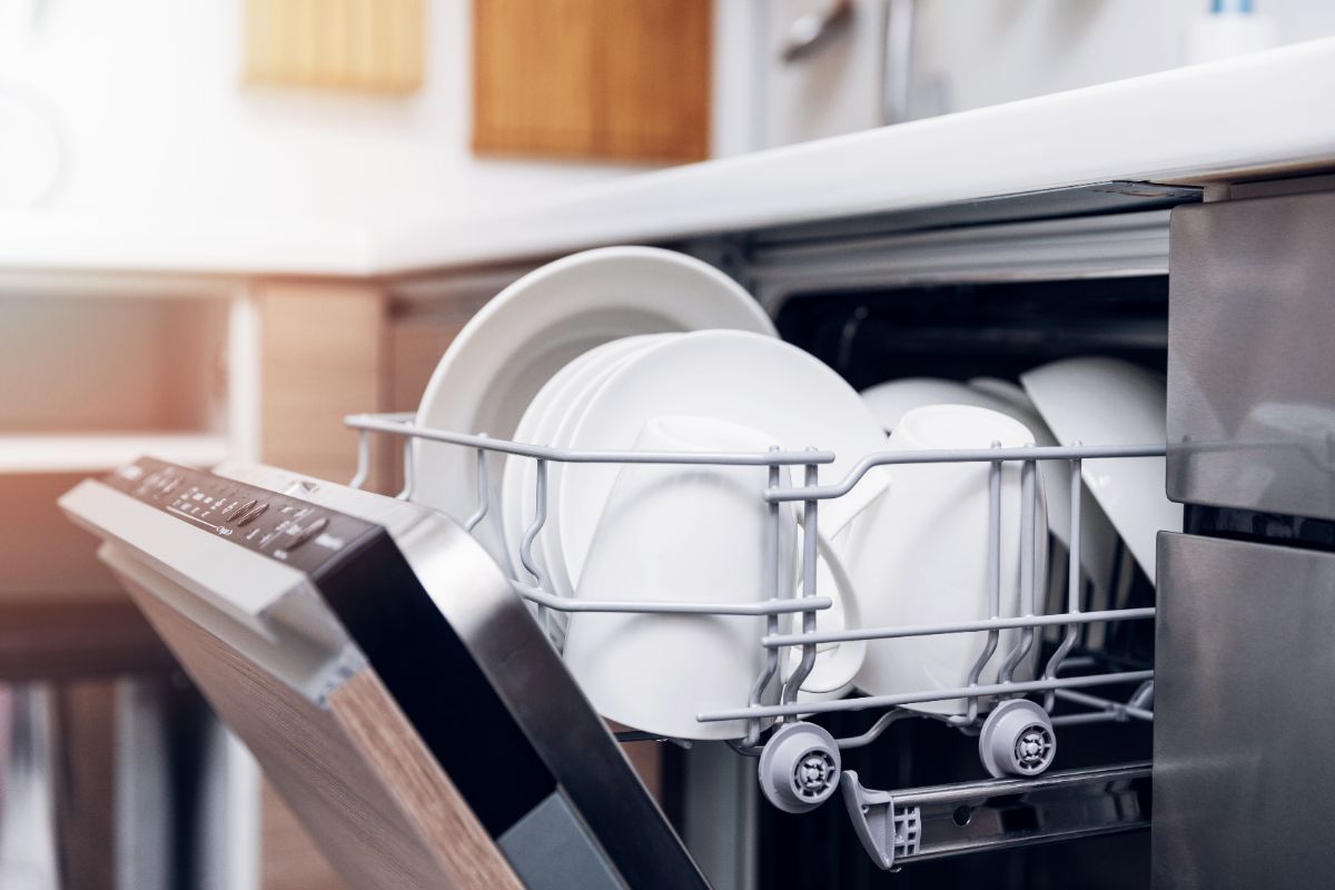 Open dishwasher with racks of dishes